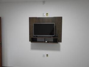 a flat screen tv sitting on a wall at Pousada Paraíso Mineiro in Capitólio
