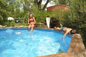 a boy and a girl sitting in a swimming pool at Ca' Barbona in Lido di Classe