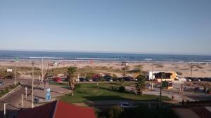 ein Parkplatz am Strand mit dem Ozean im Hintergrund in der Unterkunft Litoral Hotel Arroio do Sal in Arroio do Sal