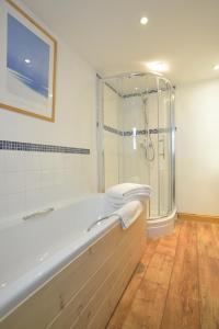 a bathroom with a bath tub and a shower at Althea House with parking in Padstow