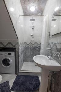 a bathroom with a sink and a shower and a washing machine at Holiday Cottage in Ureki