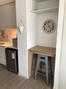 a kitchen with a table and a clock on the wall at Apartamento de Lujo. Frente Mall Plaza in Antofagasta +10 photos