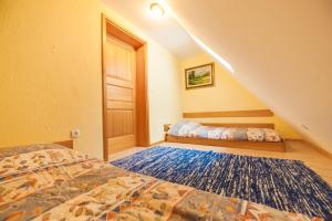 a bedroom with two beds and a staircase at APARTMENTS ROGLA LUKANJA 1 in Oplotnica