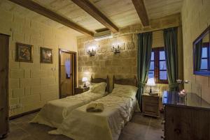 a bedroom with two beds and two tables and two lamps at Blueberry Hills in Żejtun +12 photos
