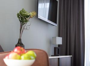 un bol de fruta sentado en un sofá con un jarrón en anders Kontorhaus Hotel en Lüneburg