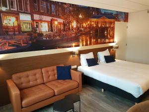 
a hotel room with a large bed and a painting on the wall at Tulip Inn Leiden Centre in Leiden
