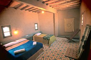 a bedroom with two beds in a room at Maison Adrar Merzouga in Merzouga