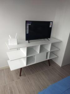 a white entertainment center with a television on it at Apartamento de Lujo. Frente Mall Plaza in Antofagasta