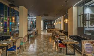 a restaurant with wooden tables and chairs and lights at Hotel B plus L in Hyderabad
