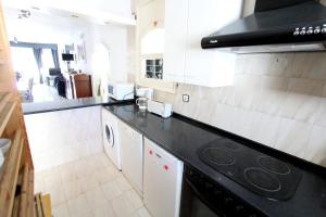 uma cozinha com um balcão preto e electrodomésticos brancos em LEON INMO Villa Jean - 10035 em Empuriabrava