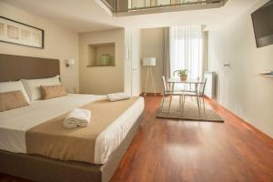 une chambre avec un grand lit et une table dans l'établissement B&B Palazzo Depretis, à Naples