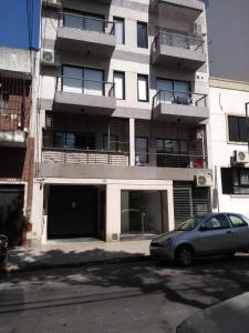 Apartamento cómodo y tranquilo con WiFi en Boedo في بوينس آيرس: سيارة متوقفة أمام مبنى