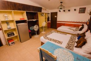 a room with two beds and a refrigerator in it at Antigua Lodge, 70 m from sandy beach in El Cuyo