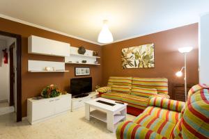 un soggiorno con divano e TV di Holi-Rent Albareda a Siviglia