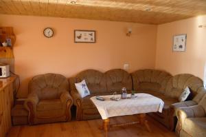 U Jędrusia في بولانكسيك: غرفة معيشة بها كنبتين وطاولة وساعة