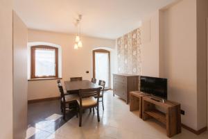 a dining room with a table and a tv at Residence Samont - Borgo Gortani in Arta Terme