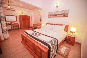 a bedroom with a large bed and a desk at Villa Paradise in Hikkaduwa