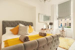 - une chambre dotée d'un grand lit avec des oreillers jaunes et oranges dans l'établissement Great King Street Residence, à Édimbourg