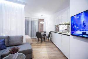 a living room with a couch and a tv and a kitchen at Glamour Centrum in Białystok