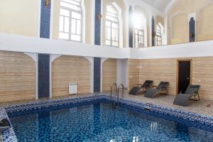 a large swimming pool with chairs in a building at Санаторий Главные Нарзанные Ванны in Kislovodsk