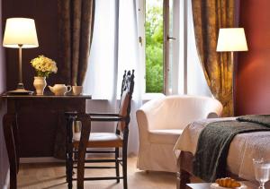 ein Schlafzimmer mit einem Bett und einem Stuhl neben einem Fenster in der Unterkunft Schlosshotel Ziethen in Kremmen