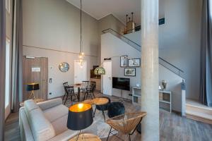 a living room with a couch and a table at HARBR. hotel Konstanz in Konstanz