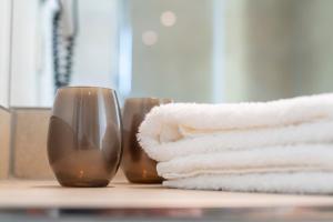 a pile of towels sitting on a counter next to a sink at HARBR. hotel Konstanz in Konstanz +37 photos