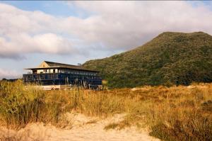 ein Haus am Strand mit einem Hügel im Hintergrund in der Unterkunft Hotel Juan de la Cosa in Santoña