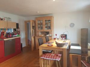 a kitchen with a wooden table with chairs and a counter at Ferienwohnung M. Fischer in Weißenregen