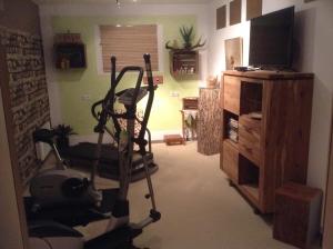 a living room with a exercise bike and a television at Ferienwohnung Christine in Tanzfleck