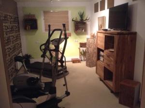 uma sala de estar com uma bicicleta de exercício e uma televisão em Ferienwohnung Christine em Tanzfleck