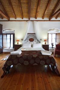 1 dormitorio con 1 cama grande y suelo de madera en Pietra Suite, en Monemvasia