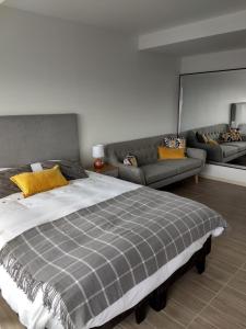 um quarto com uma cama grande e um sofá em Apartamento de Lujo. Frente Mall Plaza em Antofagasta