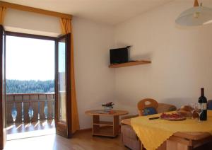 sala de estar con mesa y balcón en Haus Hafner, en Avelengo