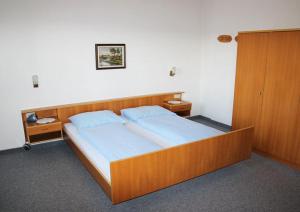 a bedroom with a large wooden bed with blue sheets at Haus Hafner in Avelengo