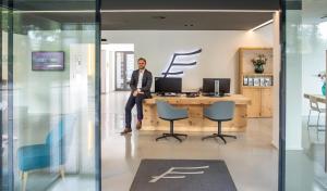 Ein Mann, der an einem Schreibtisch in einem Büro sitzt. in der Unterkunft THE FLAG Zürich in Zürich