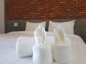twee handdoeken zittend op een bed bij Beloft Hotel in Nakhon Si Thammarat