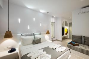 ein weißes Zimmer mit einem Bett und einem Sofa in der Unterkunft Quartano Luxury Cycladic Residence, Adults Only (13+) in Naoussa