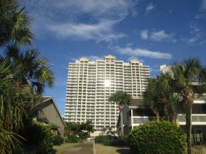 a large white building with palm trees in front of it at 122 Seascape Drive, Unit 1409 in Destin