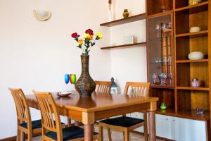 una mesa de comedor con un jarrón con flores. en Appartamento Bellavista en Cremia