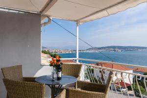 uma mesa numa varanda com vista para a água em La Bodega Apartments em Trogir