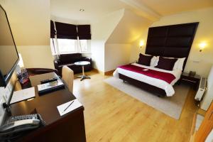 1 dormitorio con 1 cama y escritorio con ordenador en Glynhill Hotel & Spa near Glasgow Airport, en Renfrew