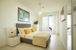a bedroom with a large bed with yellow pillows at Residence Serenissima in Bibione +68 photos