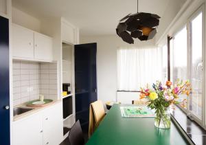 a kitchen with a table with a vase of flowers on it at SWEETS - Gerben Wagenaarbrug in Amsterdam