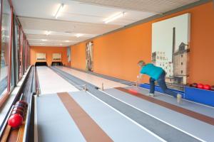mężczyzna grający w kręgle w kręgielni w obiekcie JUFA Hotel Weinviertel - Eselsmühle w mieście Seefeld