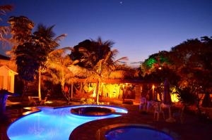 two pools in a backyard at night with lights at Pousada Cristal da Terra in Sao Jorge