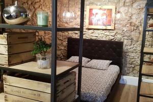 Zimmer mit einem Bett und einem Regal mit Weinflaschen in der Unterkunft Balnéo Room, Loft Déco Authentique, Jacuzzi, Centre, Climatisation in Sète