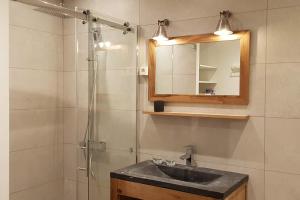 La salle de bains est pourvue d'un lavabo et d'une douche avec un miroir. dans l'établissement Romantic Room, Balnéo, Jacuzzi, Loft Authentique au sein du Quartier Haut Historique et Central, Climatisation, à Sète