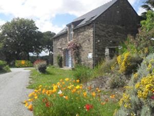 a stone house with flowers in front of it at L'Eternet in Malansac