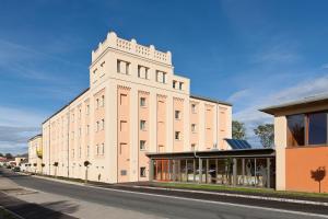 duży biały budynek na poboczu ulicy w obiekcie JUFA Hotel Weinviertel - Eselsmühle w mieście Seefeld